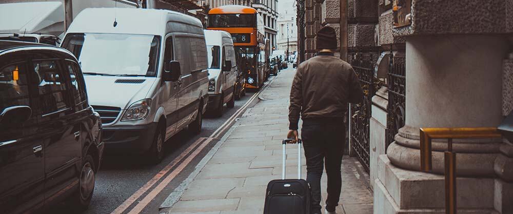 Man with suitcase walking through London