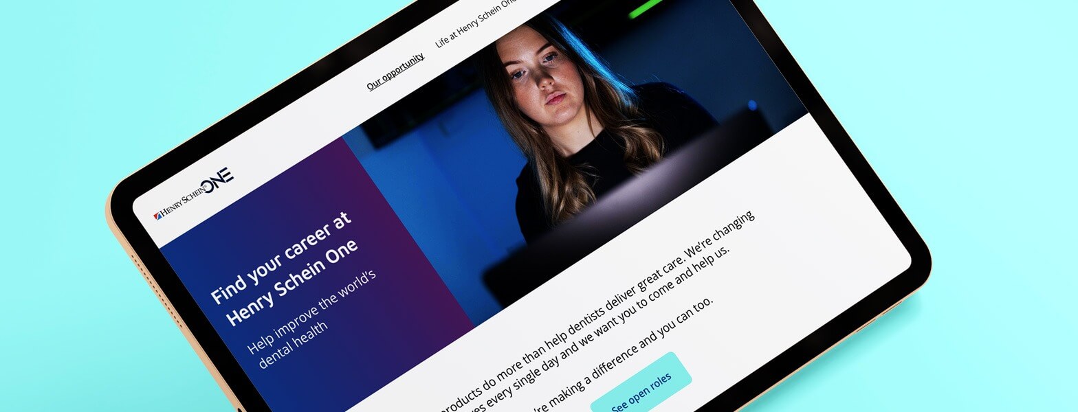 Tablet displaying Henry Schein one website with a blue background