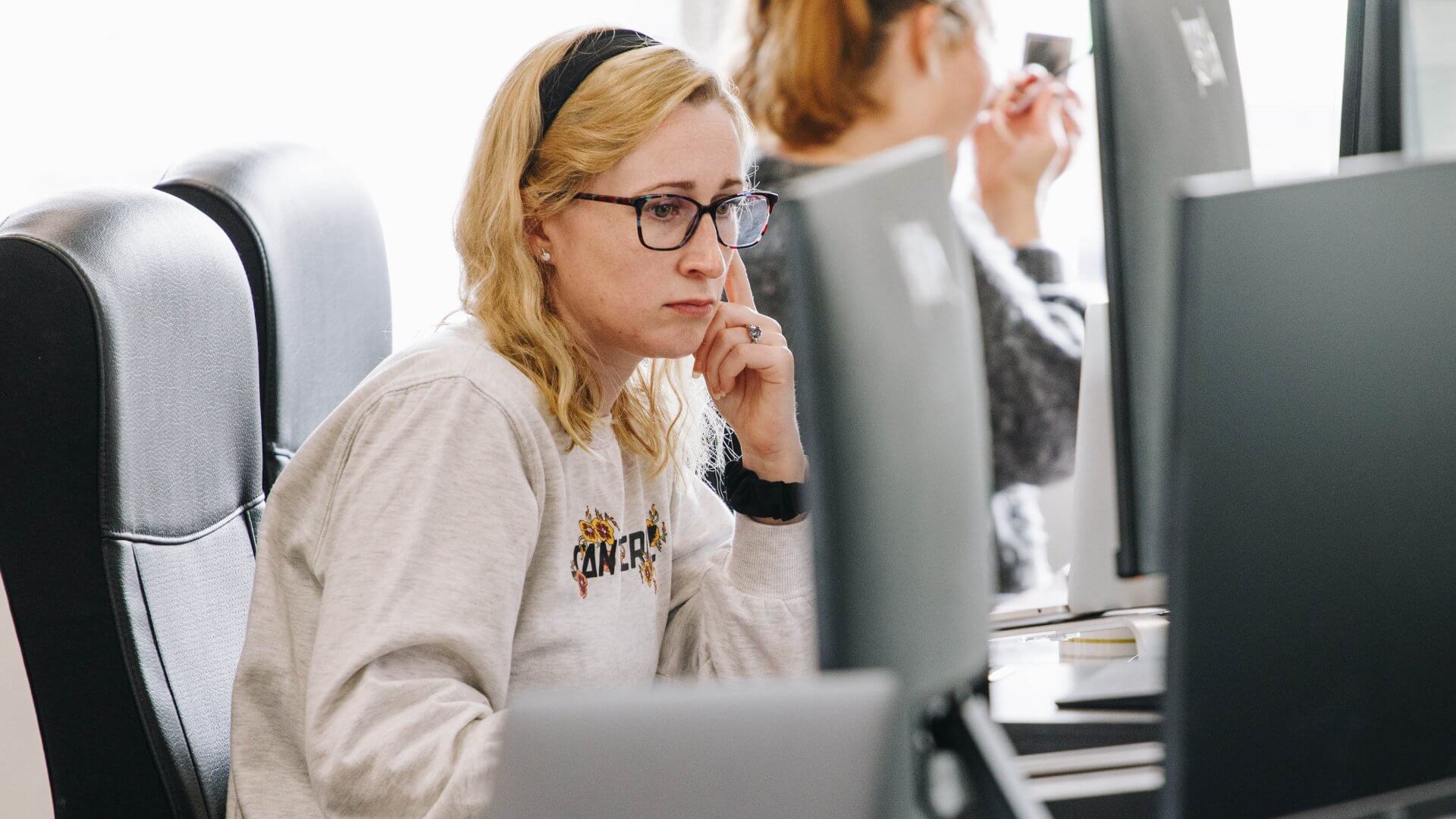 Woman with blonde hair on laptop in an office