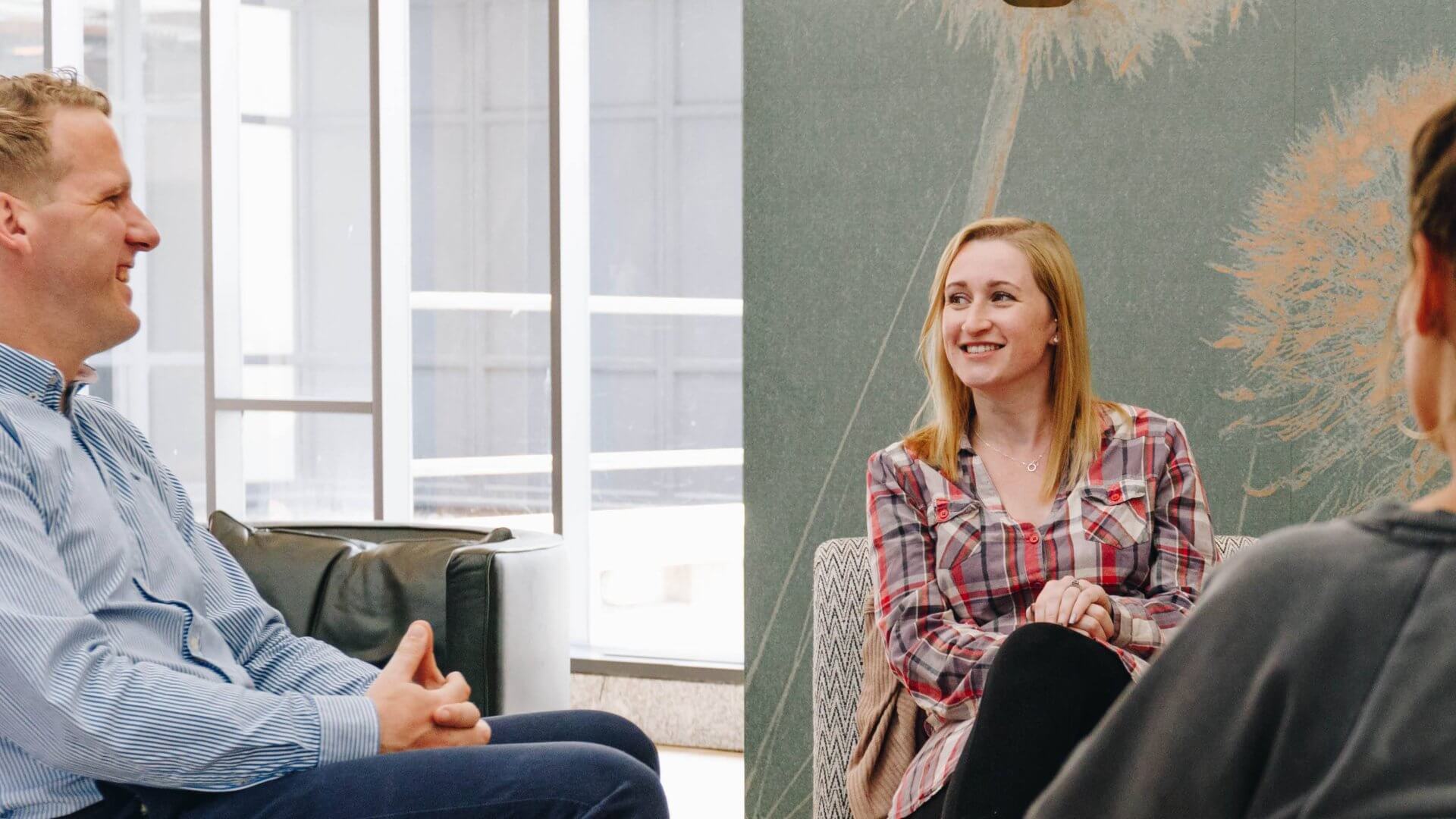 two women and one man in a discussion about work