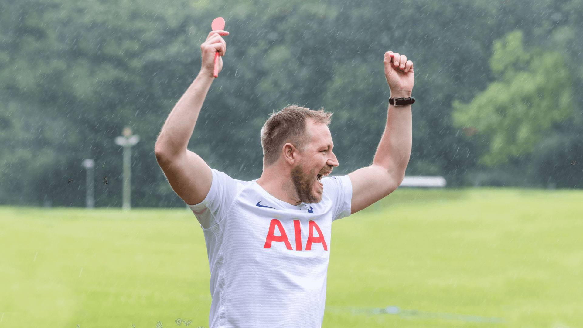 Man in the rain cheering with a spoon