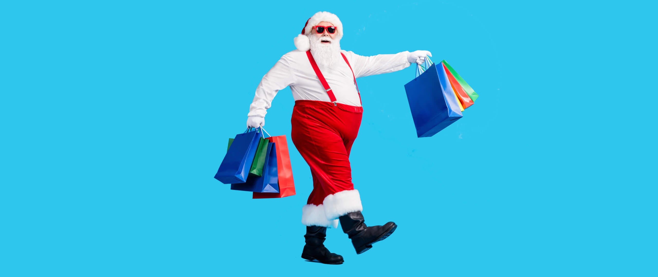 Full length profile side photo of crazy modern white grey hair bearded santa claus go shopping buy x-mas christmas bags wear red suspenders overalls boots isolated blue color background
